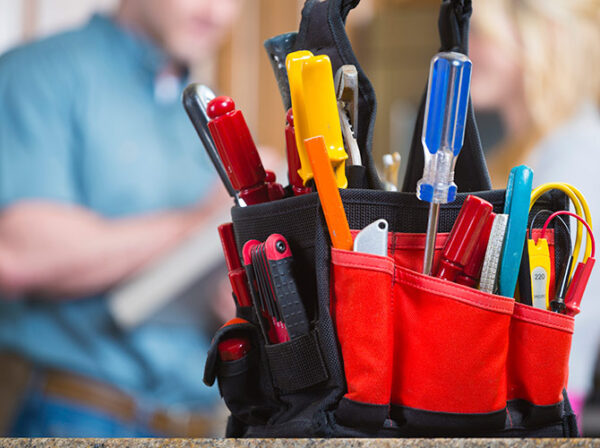 Bag of tools sitting on a counter with two people talking in the background