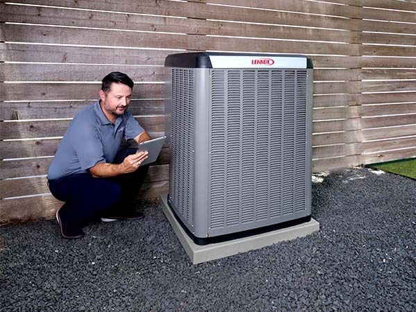 ACInstallation_600x450-1 Air Conditioner technician crouching next t AC unit