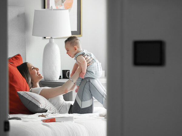 Mom holding her baby while sitting on a bed