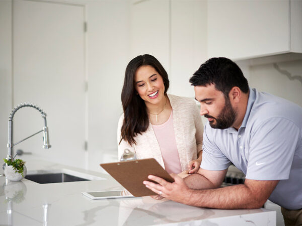 Man and woman looking at a clipboard in a spotless kitchen